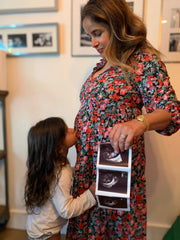 A woman holds an ultrasound picture, symbolizing anticipation and care, aligned with WeNatal's prenatal focus.